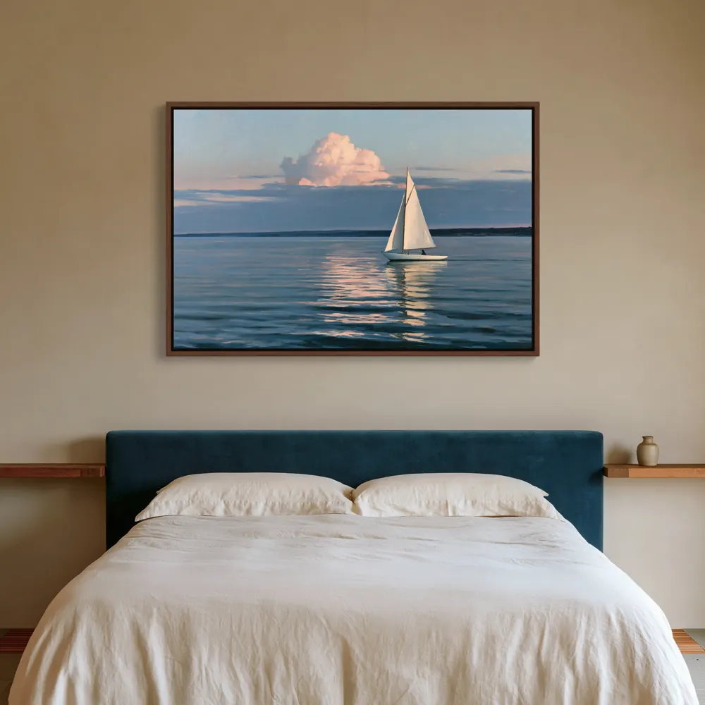 A sailboat-at-dusk painting as a dark wood floating-frame canvas above a bed with a navy upholstered headboard