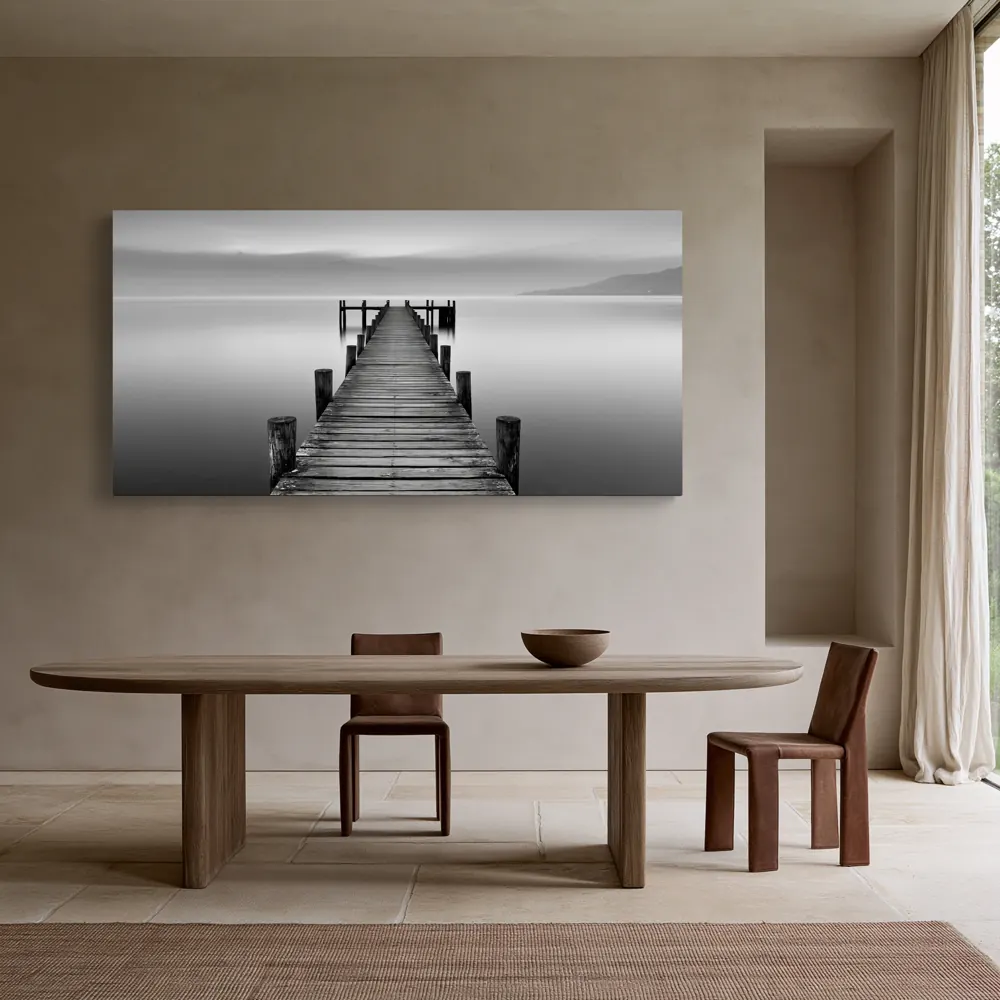 A black-and-white lake pier photograph as a stretched canvas in the Belgian linen dining room