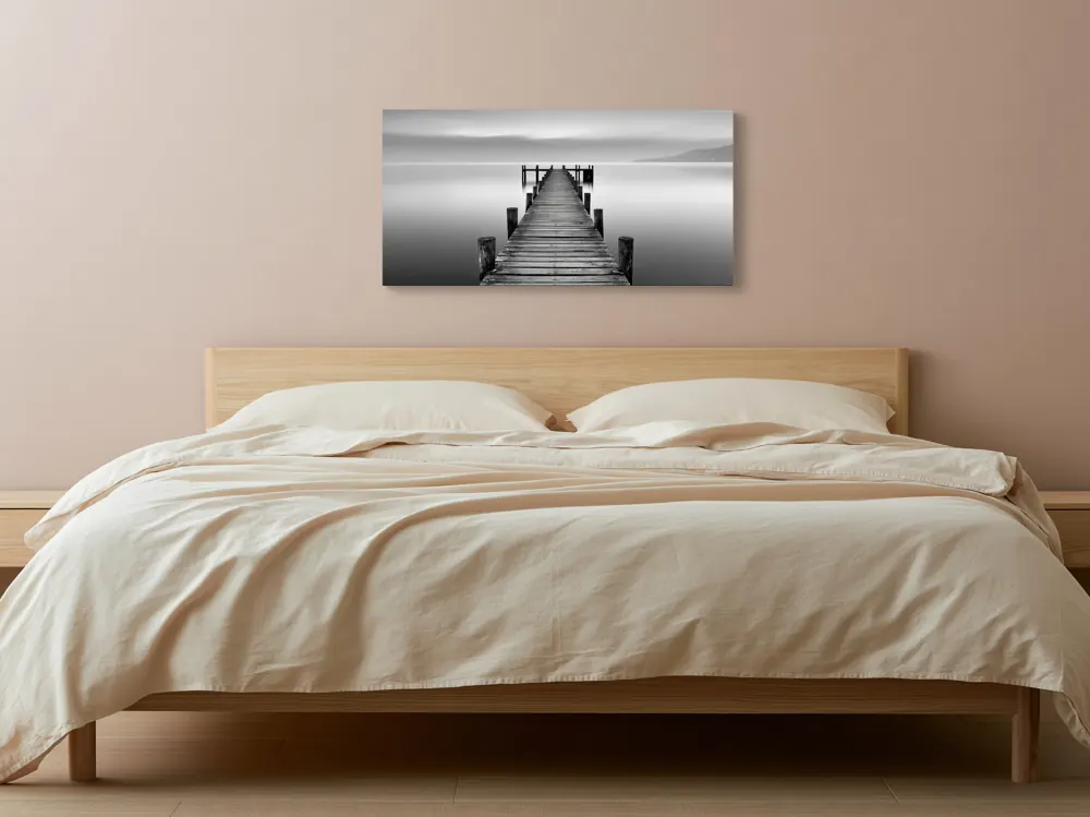 A black-and-white lake pier photograph as a stretched canvas in the Blush linen bedroom