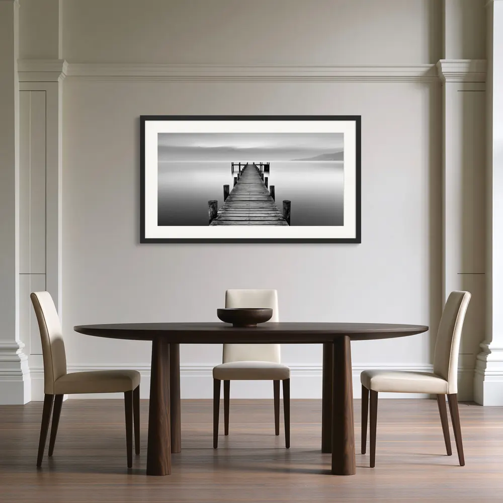 A black-and-white lake pier photograph as a black framed print with a white mat in the Contemporary-classical dining