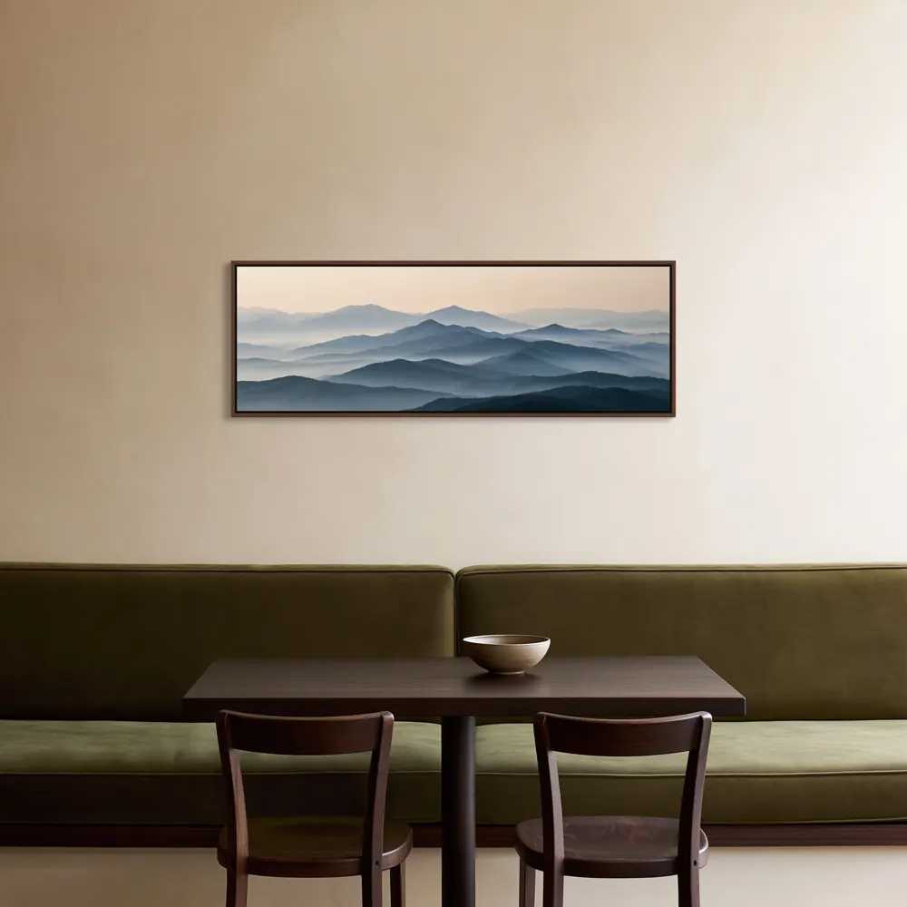 A misty mountain panorama as a walnut floating-frame canvas in the Cream restaurant banquette