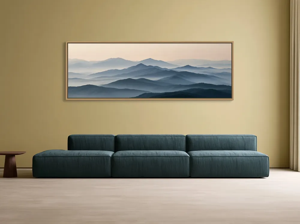 A misty mountain panorama as a natural oak floating-frame canvas in the Ochre wall teal sofa
