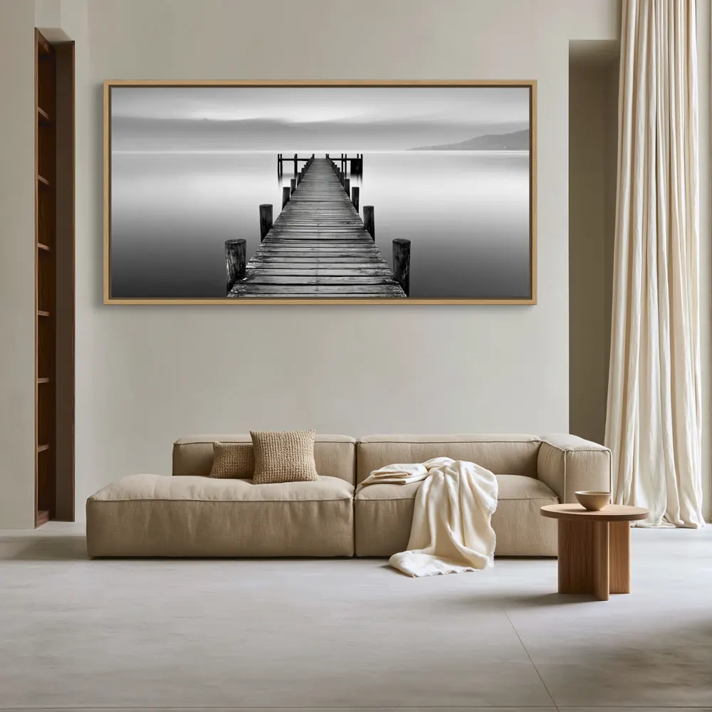 A black-and-white lake pier photograph as a natural oak floating-frame canvas in the Pearl-grey residential salon