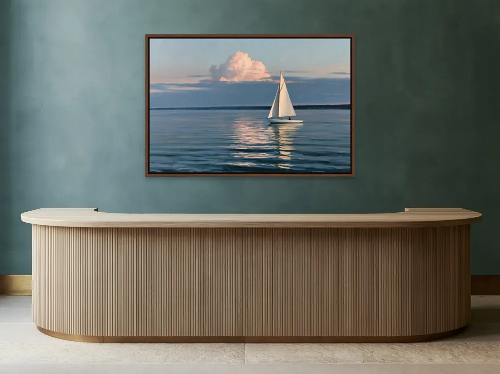 A sailboat-at-dusk oil painting as a walnut floating-frame canvas in the Petrol reception counter