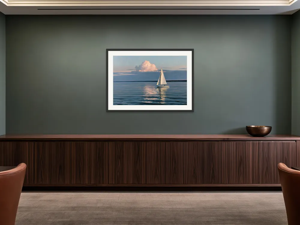 A sailboat-at-dusk oil painting as a black framed print with a white mat in the Petrol walnut office credenza